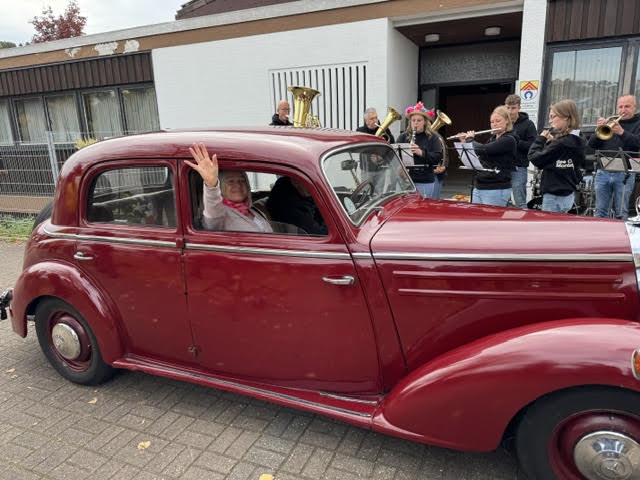 Roter Oldtimer und Blasorchester beim Kerweumzug in Lemberg
