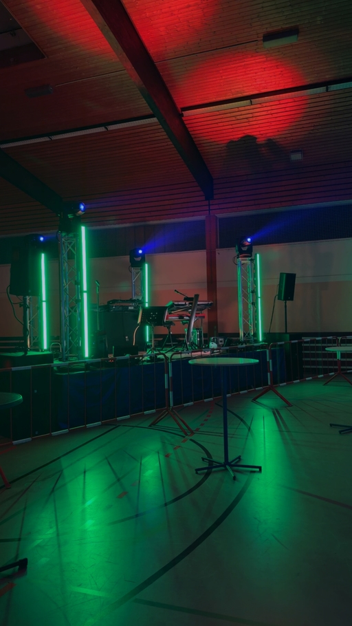 Bühne in der Freizeithalle mit grünem und rotem Licht vor der Partynacht