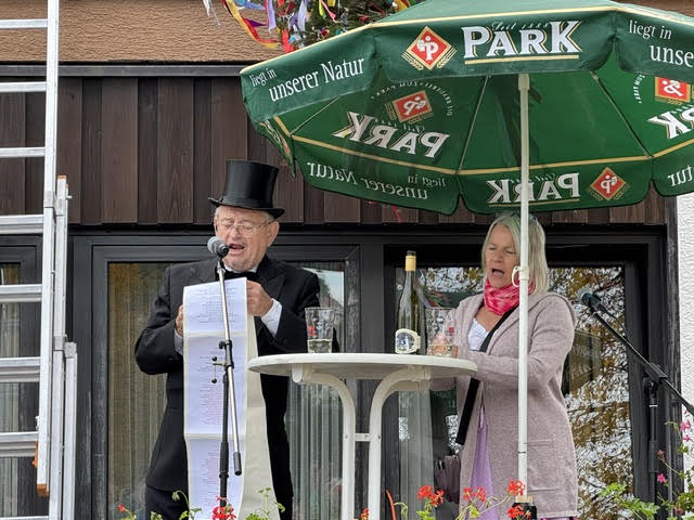 Taufe des Kerwestrauß mit Redner am Mikrofon unter dem Park-Schirm
